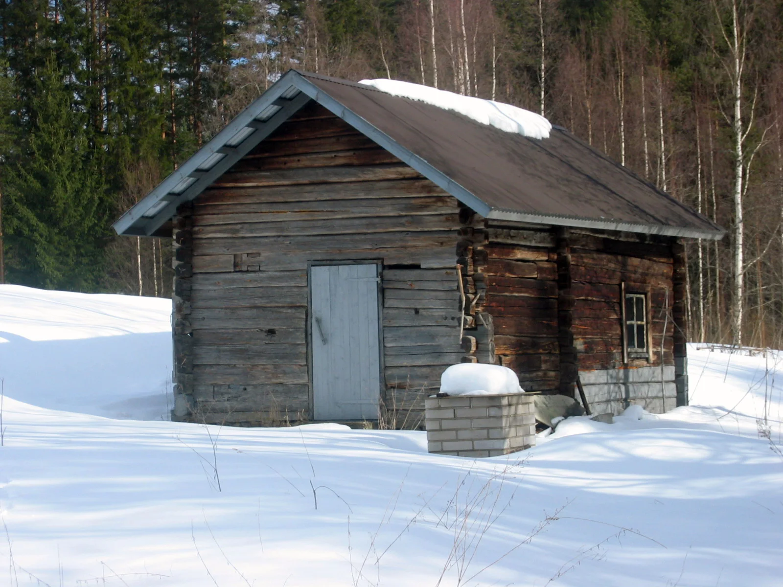 Construção de madeira de uma sauna finlandesa cercada por neve.